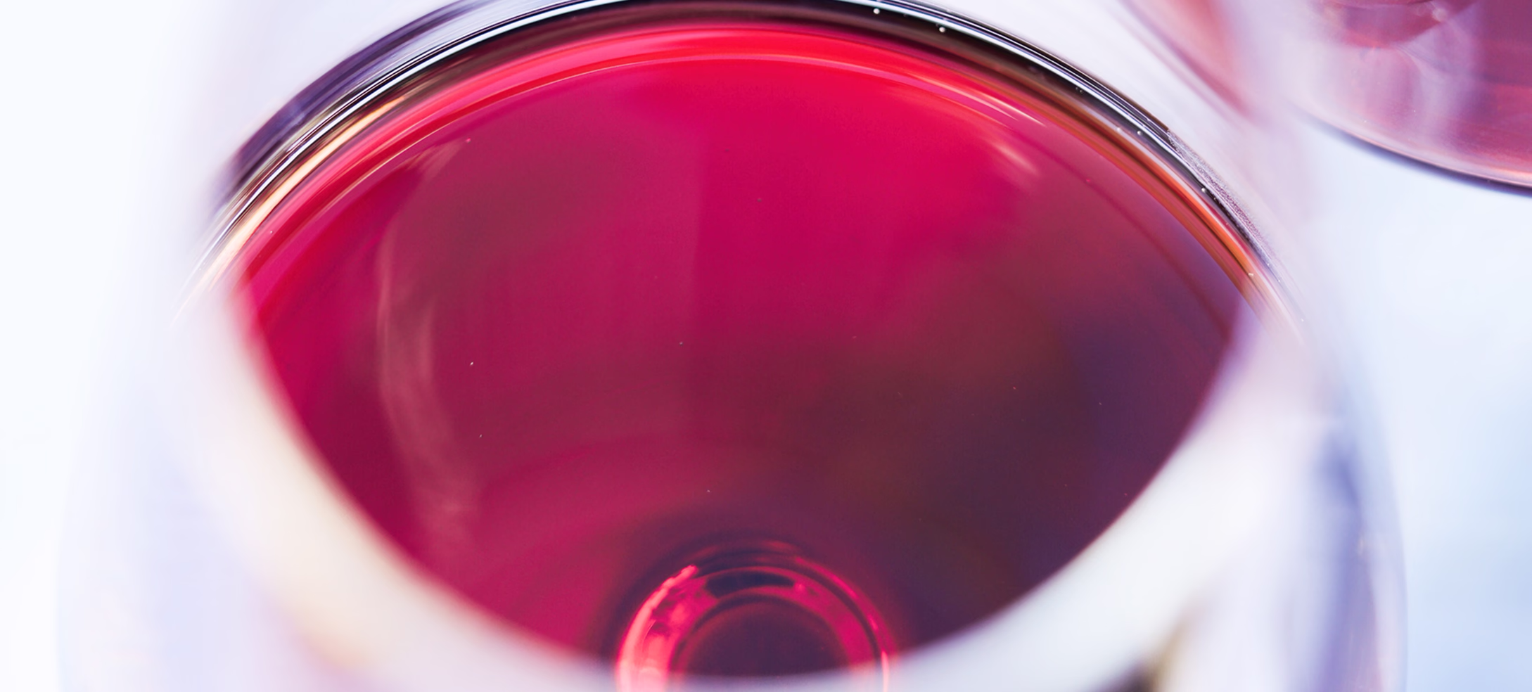 Close view of red wine in a tasting glass from above
