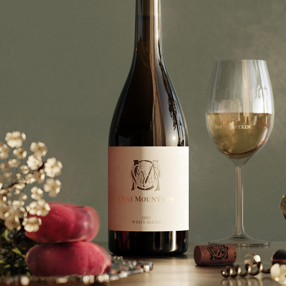 Ojai Mountain 2025 White Blend with a poured glass, blossoms and peaches