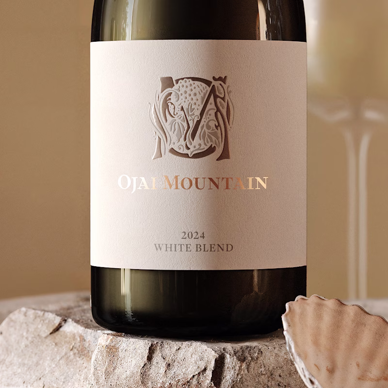 Ojai Mountain 2024 White Blend label on a stone plinth beside a shell