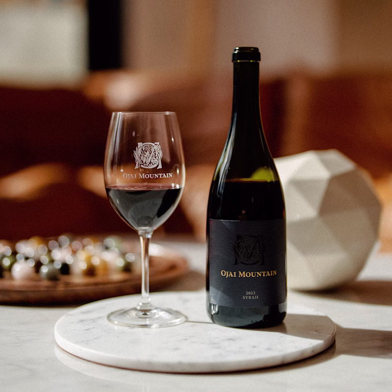 Ojai Mountain 2023 Syrah with a poured glass on a marble table