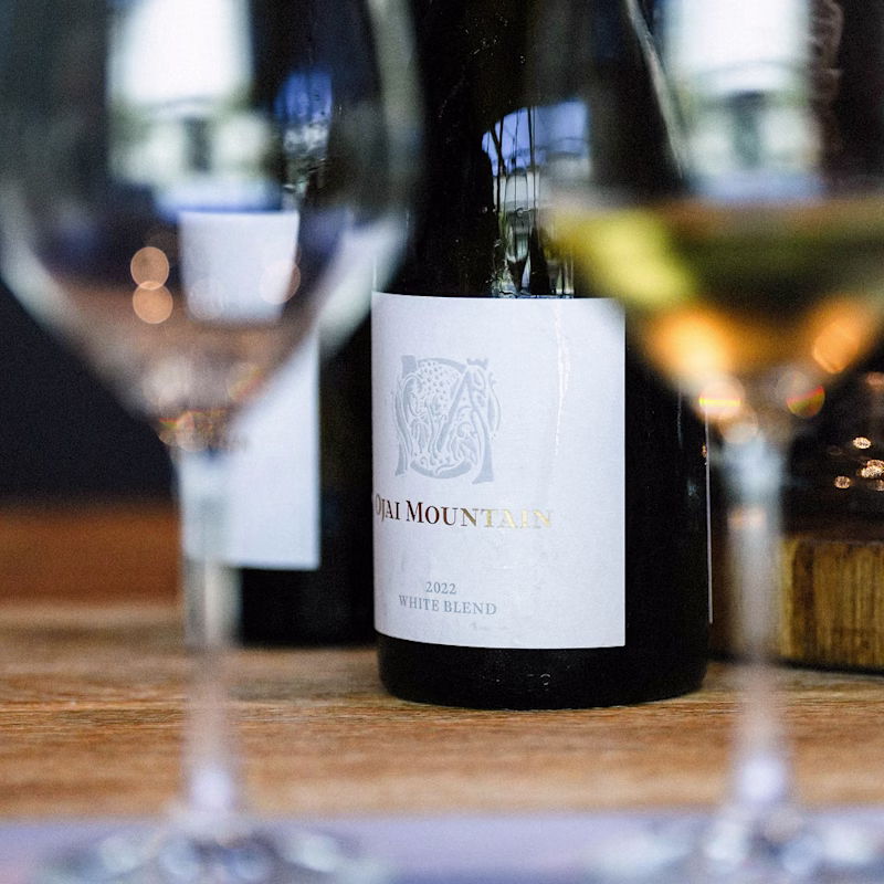 Ojai Mountain White Blend bottle framed between tasting glasses