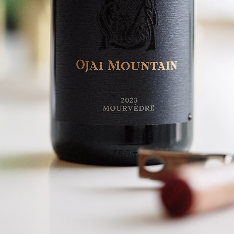Close view of the Ojai Mountain 2023 Mourvèdre bottle beside a corkscrew Close view of the Ojai Mountain 2023 Mourvèdre bottle beside a corkscrew