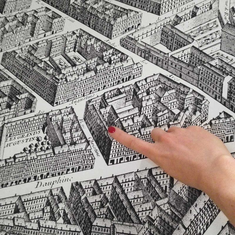 Finger pointing at map of Paris in Relais Christine