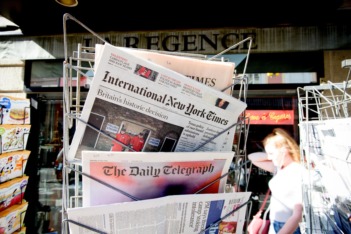 A rack of newspapers outside an off-licence.