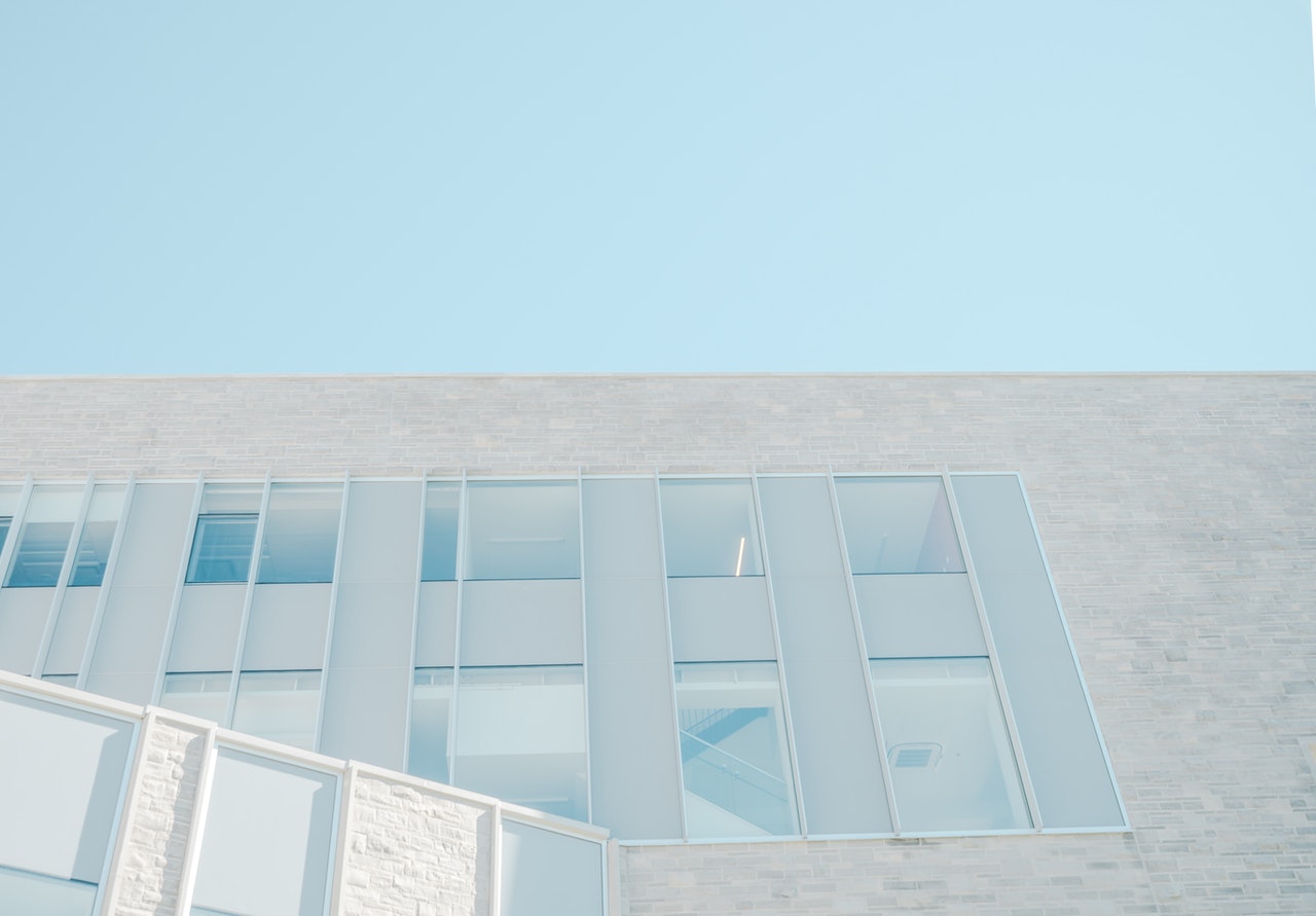 view of pale newly built block of flats against a blue sky