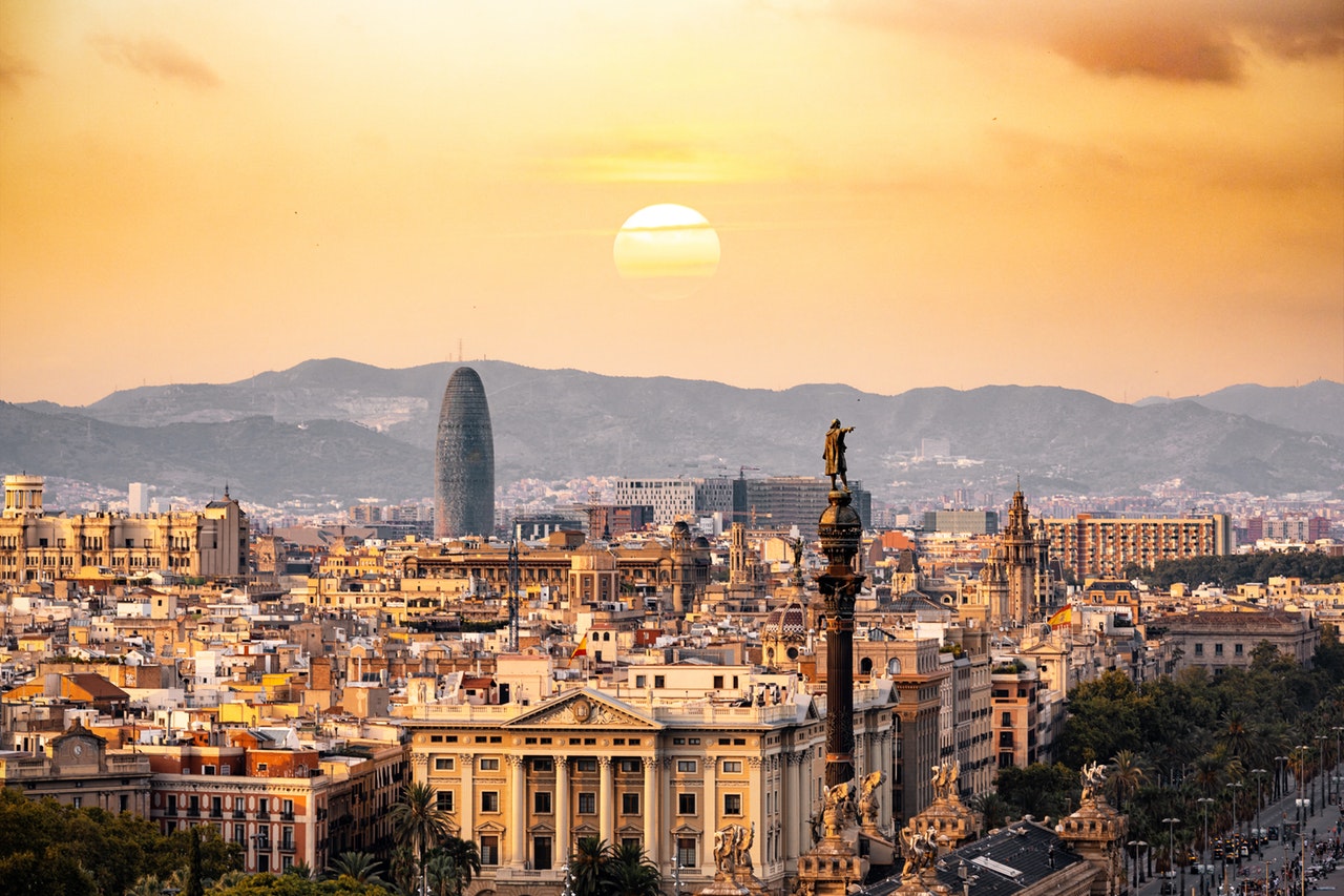 view of sunset over an old city, hills in the distance
