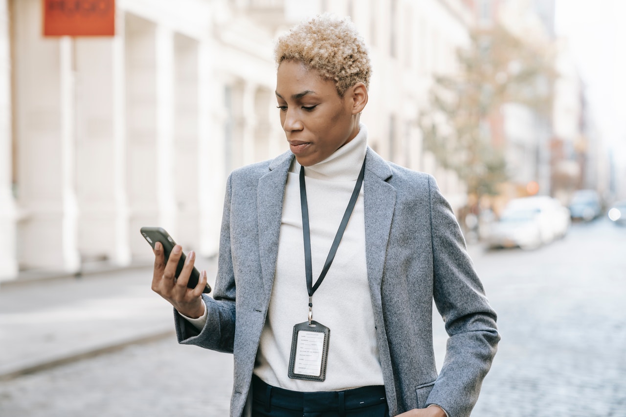 Business person checking the status of their smart home on their smartphone as they walk down a city street
