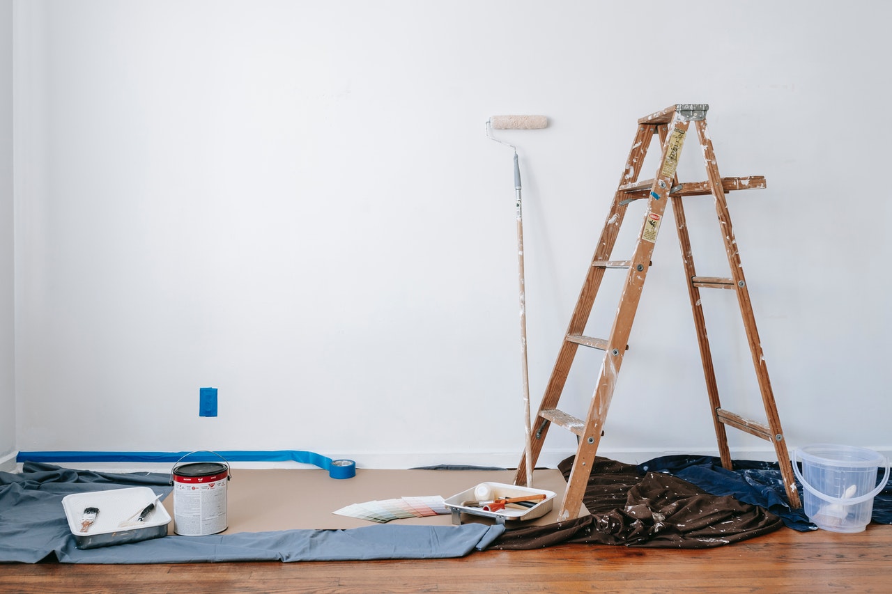 A selection of tools and a ladder in an empty room ready for someone to do repairs