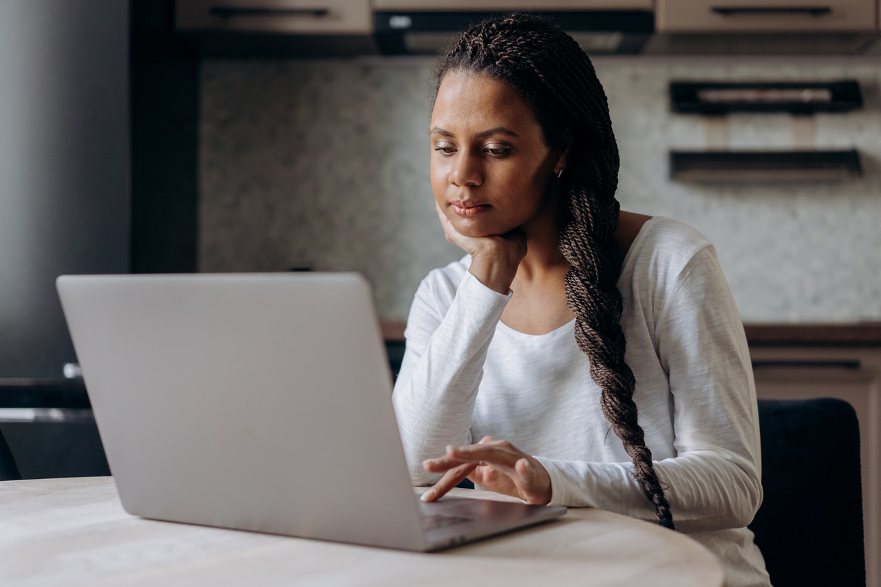Woman looking at her laptop at kitchen table.