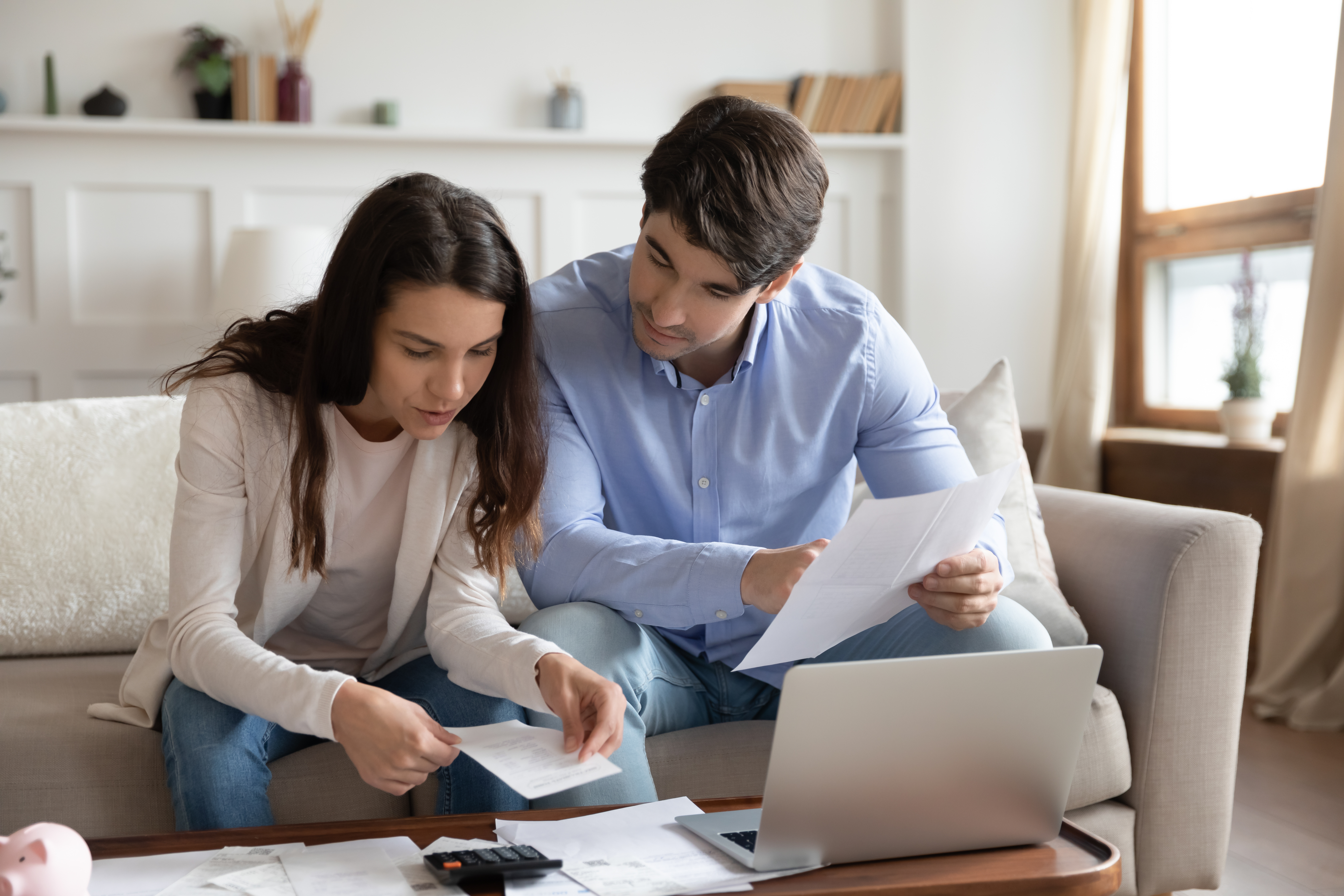 A couple sitting on a sofa and working through a document.