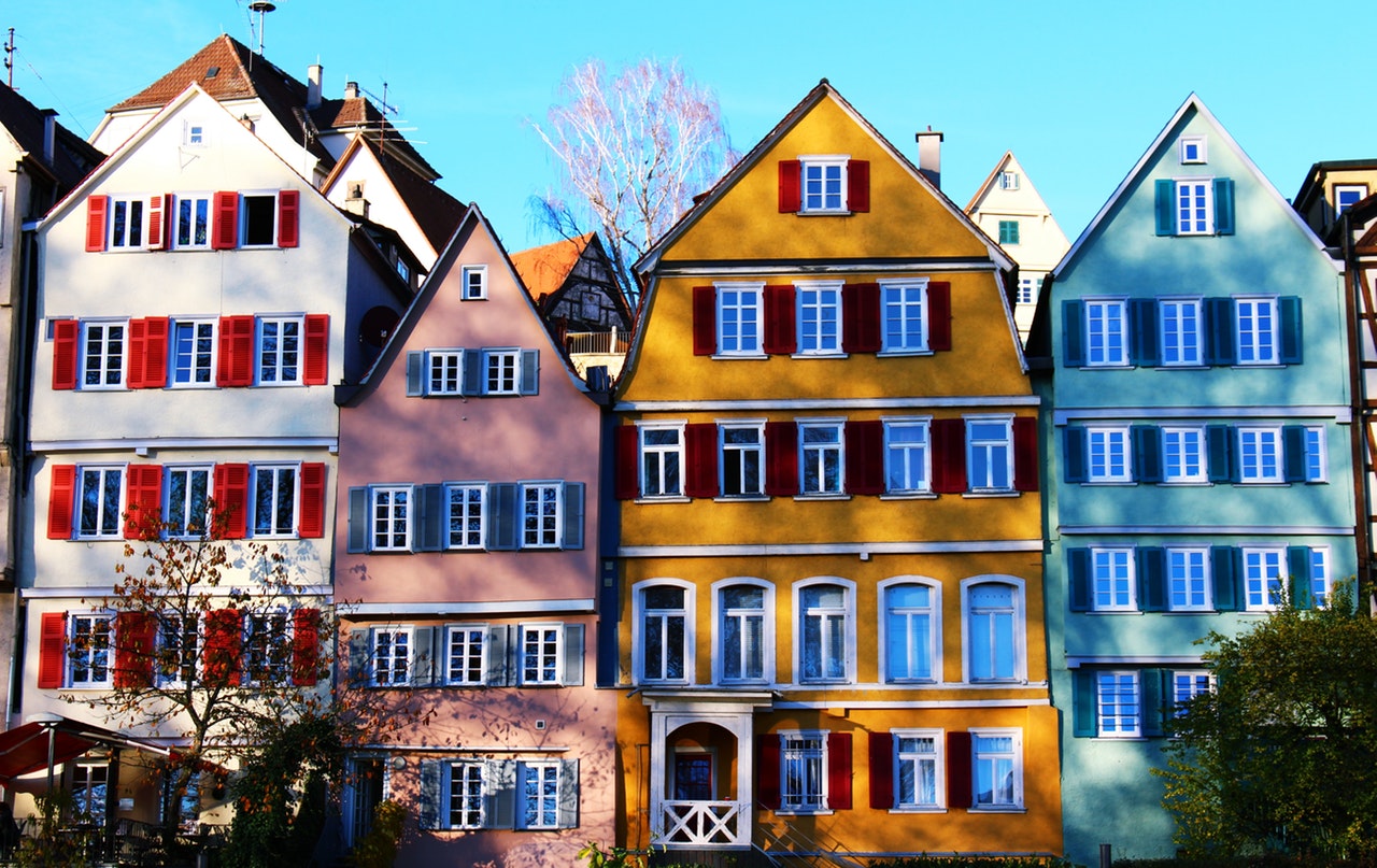 a row of houses painted in bright colours, with contrasting window shutters