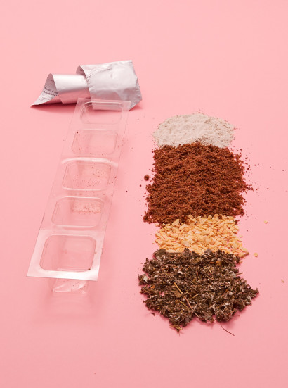 Supplements poured out of SmartPak on a pink background