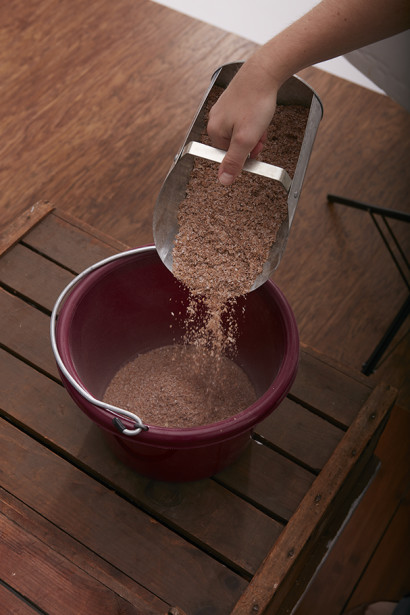 Bran mash being poured into a horse's feed tub