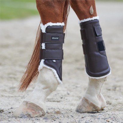 Brown fleece sport boots on a horse's hind legs.