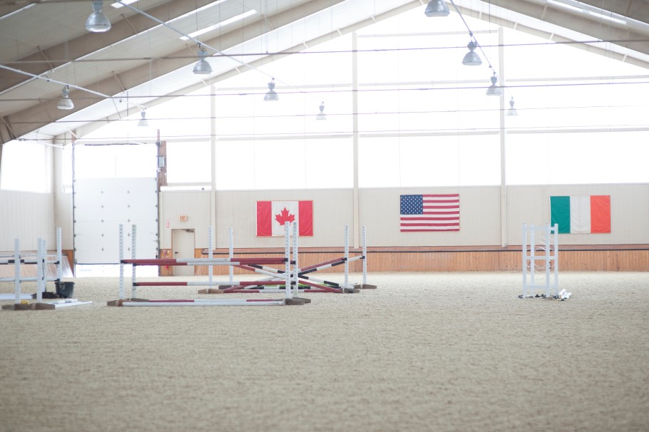 Indoor riding arena with a jump course set up. 