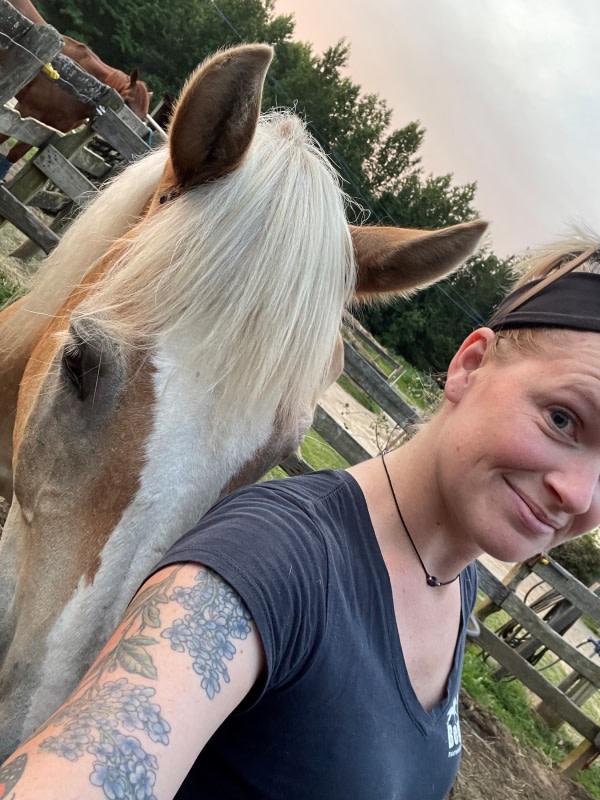 Selfie of woman with beautiful floral tattoo and her palomino Halflinger