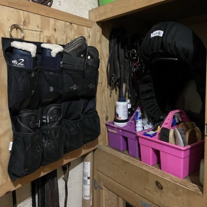 organized hangers and grooming totes in a horse tack trunk