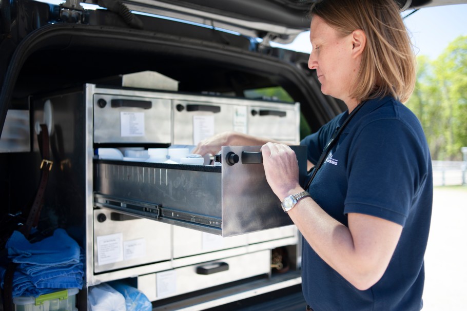 Veterinarian getting supplies out of her truck.