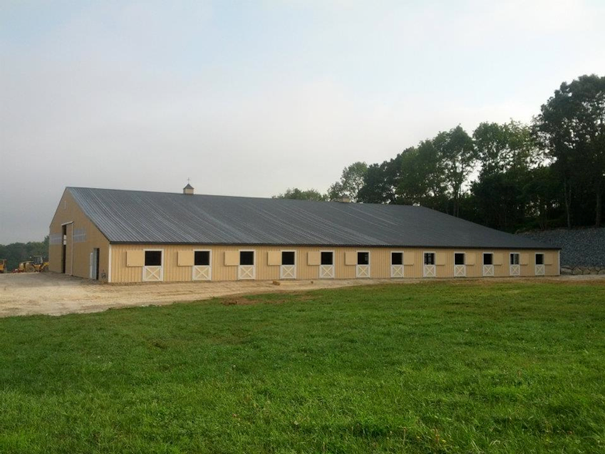 A newly constructed horse barn and indoor arena.