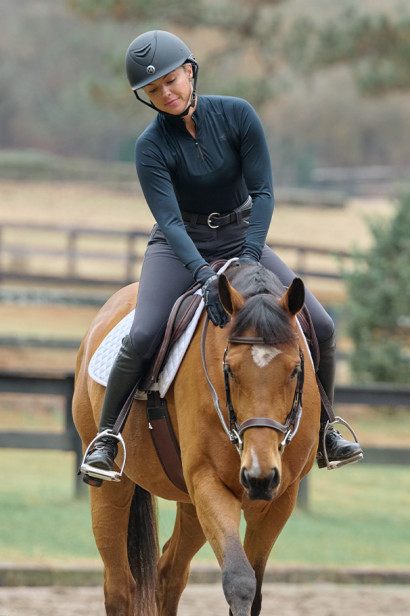 A rider positively rewarding her horse with a pat