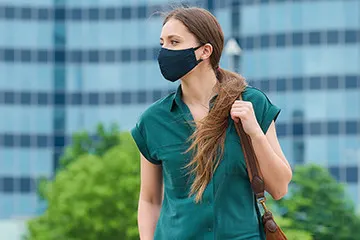  woman standing outside with a facemask on
