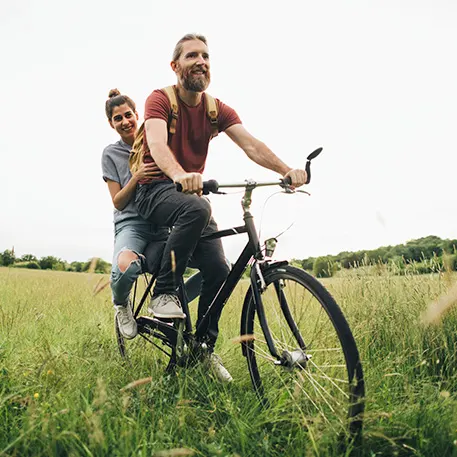 man and woman riding a bike pain free in