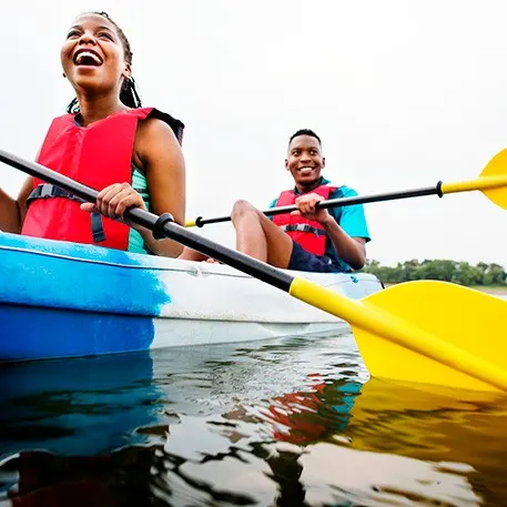  Two young people rowing in canoe. 