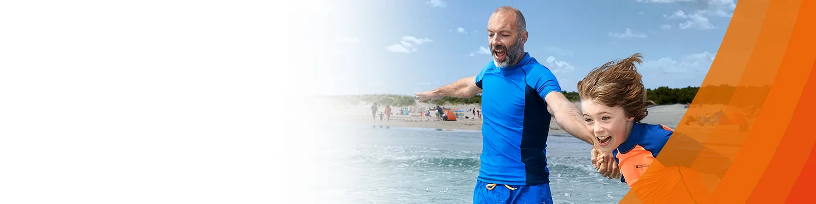 Father and son rushing into the sea cheerfully on