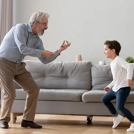 Man plays with grandson at home bending knees free