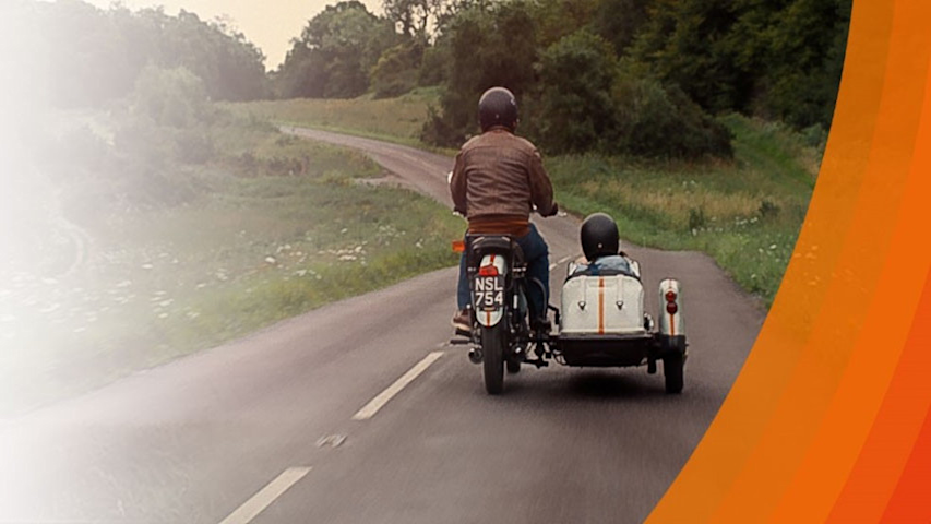 Man on motercycle with child in sidecar