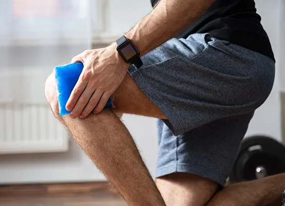 Man holds ice pack on knee