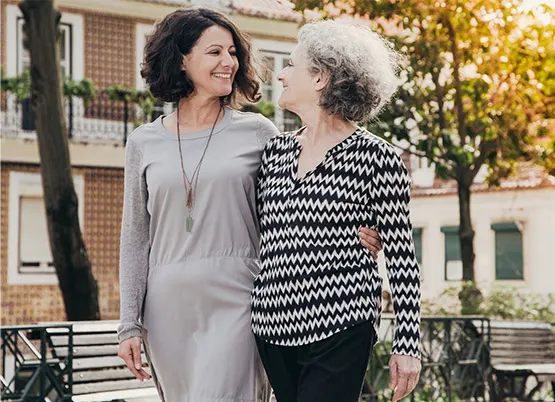  Younger woman and older woman walking together down a street
