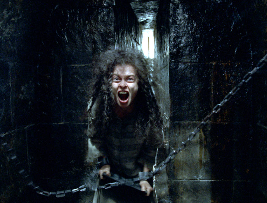 Bellatrix Lestrange in her Azkaban cell. She has chains round her wrists and she is screaming.