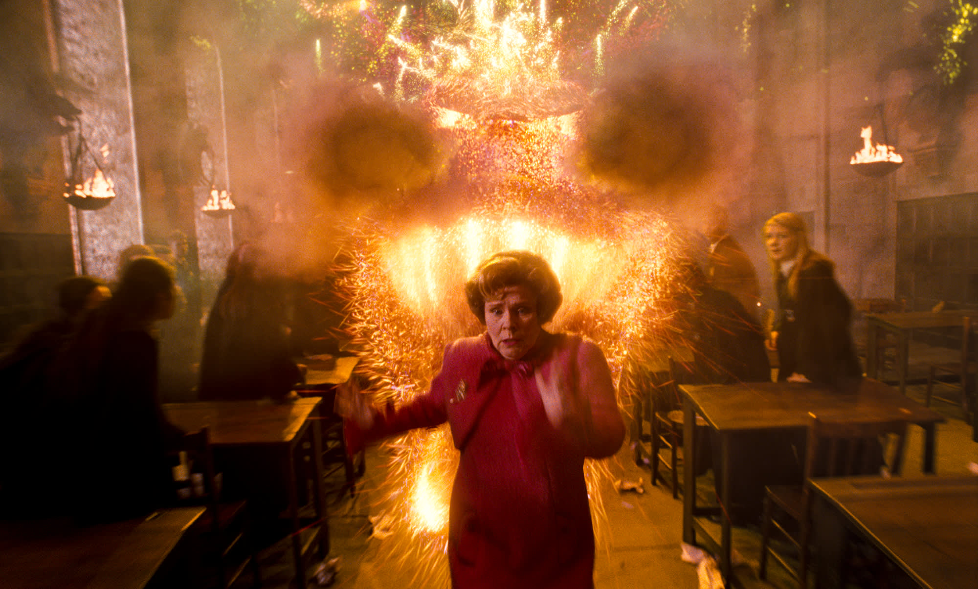Professor Umbridge being chased through the Great Hall by a fireworks in the shape of a large dragon.
