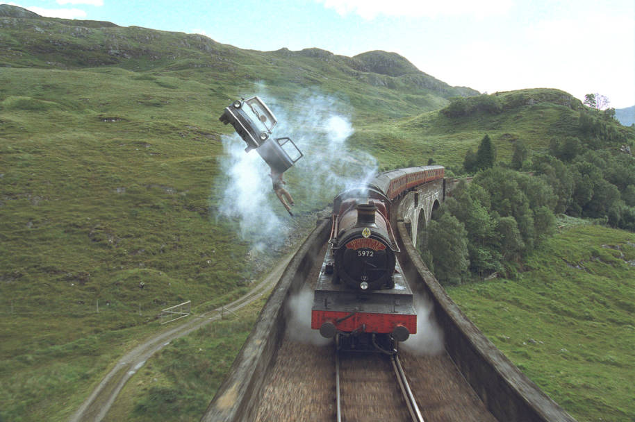 Ford Anglia flying over the Hogwarts Express with Harry falling out 