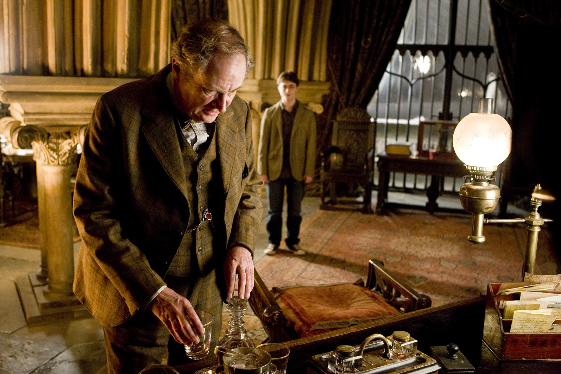 WB-HP-f6-slughorn-examining-potions-while-harry-looks-on-web-landscape