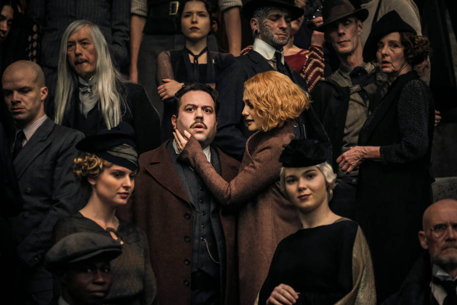 Queenie and Jacob in the crowd at Grindelwald's rally. Jacob looks concerned and Queenie is stroking his face.