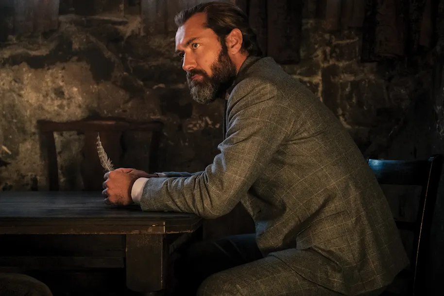 FB-F3-the-secrets-of-dumbledore-dumbledore-sat-table-holding-feather-hogs-head-web-landscape?w=914&q=70&fm=webp