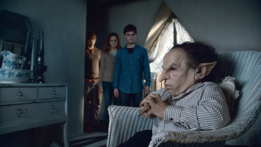 Griphook sitting in a seat at Shell Cottage with Harry Ron and Hermione 