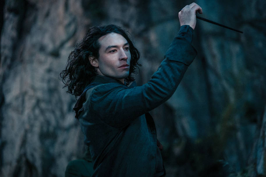 Credence looks serious while raising his wand in the air