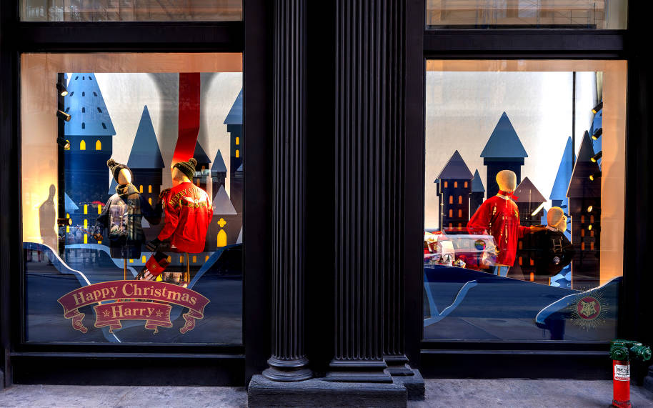 The Harry Potter New York window display. The window says Happy Christmas Harry. The mannequins are wearing different Christmas themed tops and a Weasley jumper.
