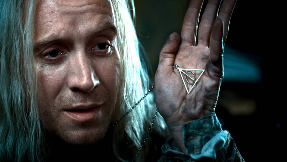 Xenophilius Lovegood holding his Deathly Hallows Pendant.