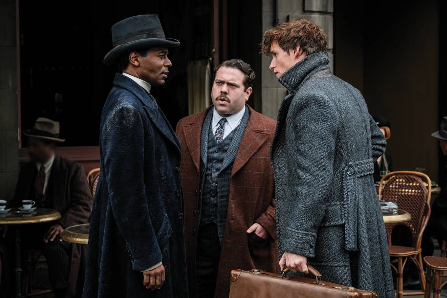 Newt, Jacob and Yusuf standing facing each other while deep in conversation.