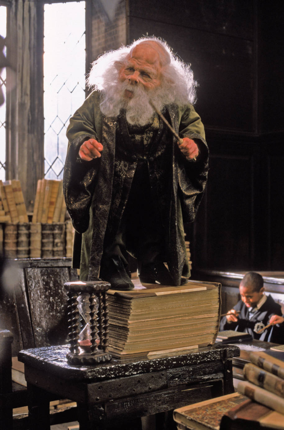 Flitwick standing on a stack of books 
