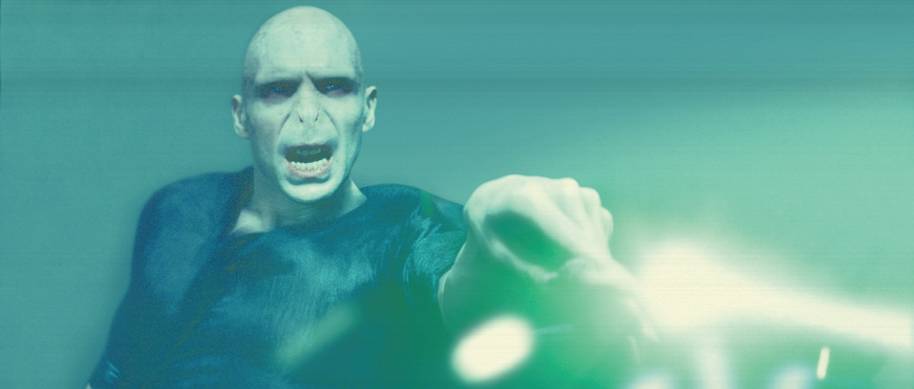 A green beam comes from Voldemort's wand after he casts a killing curse.