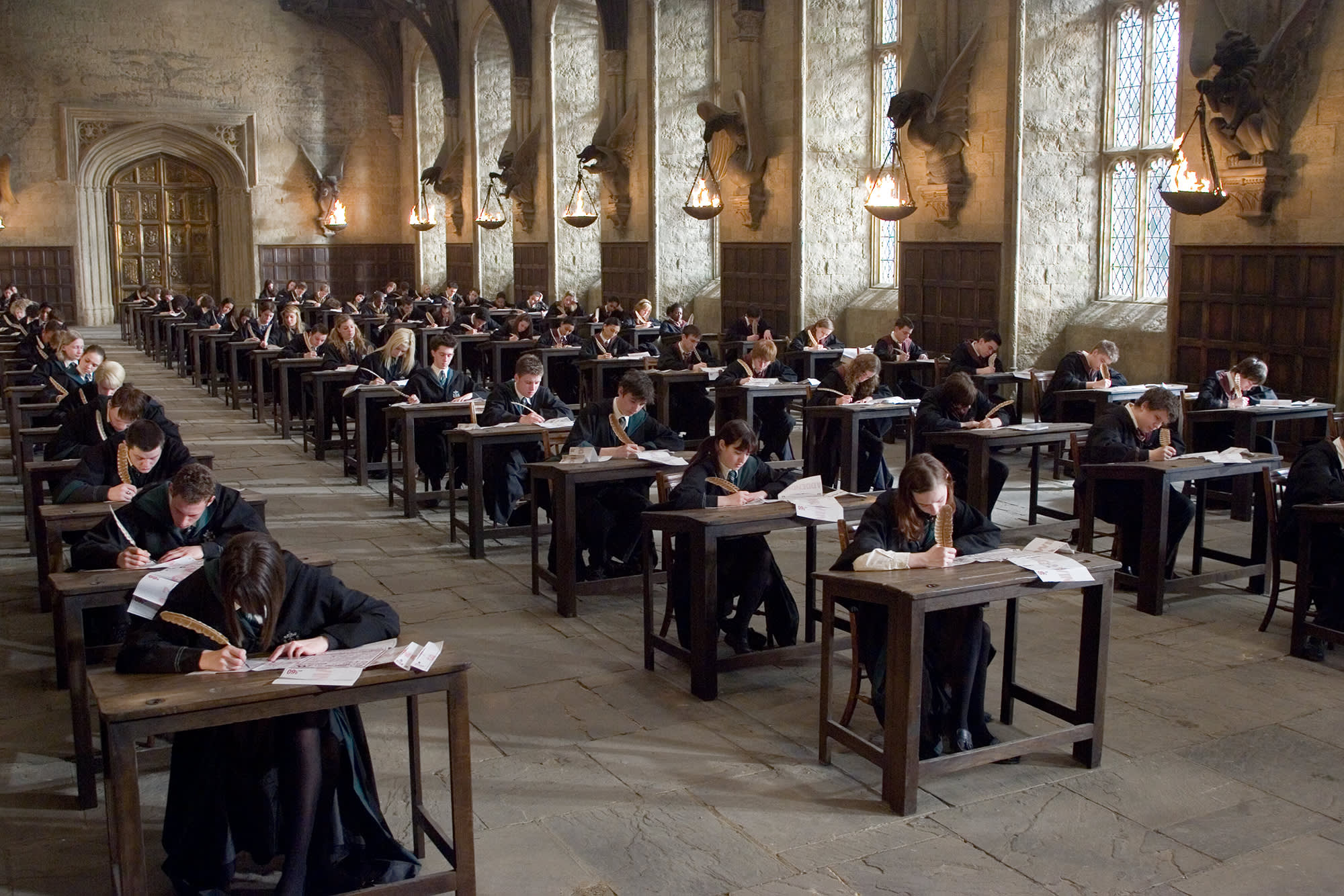 Hogwarts students sat at exam desks in rows in the Great Hall