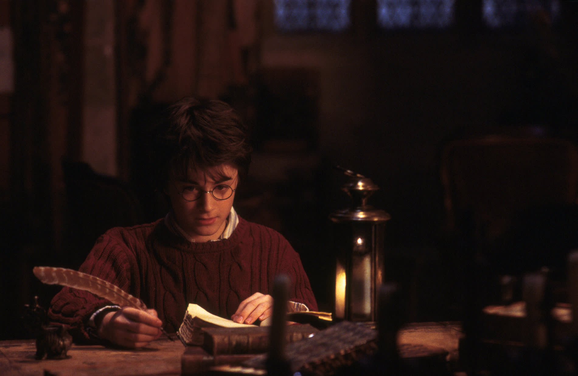 WB-HP-F1-harry-at-desk-with-quill-candle-web-landscape