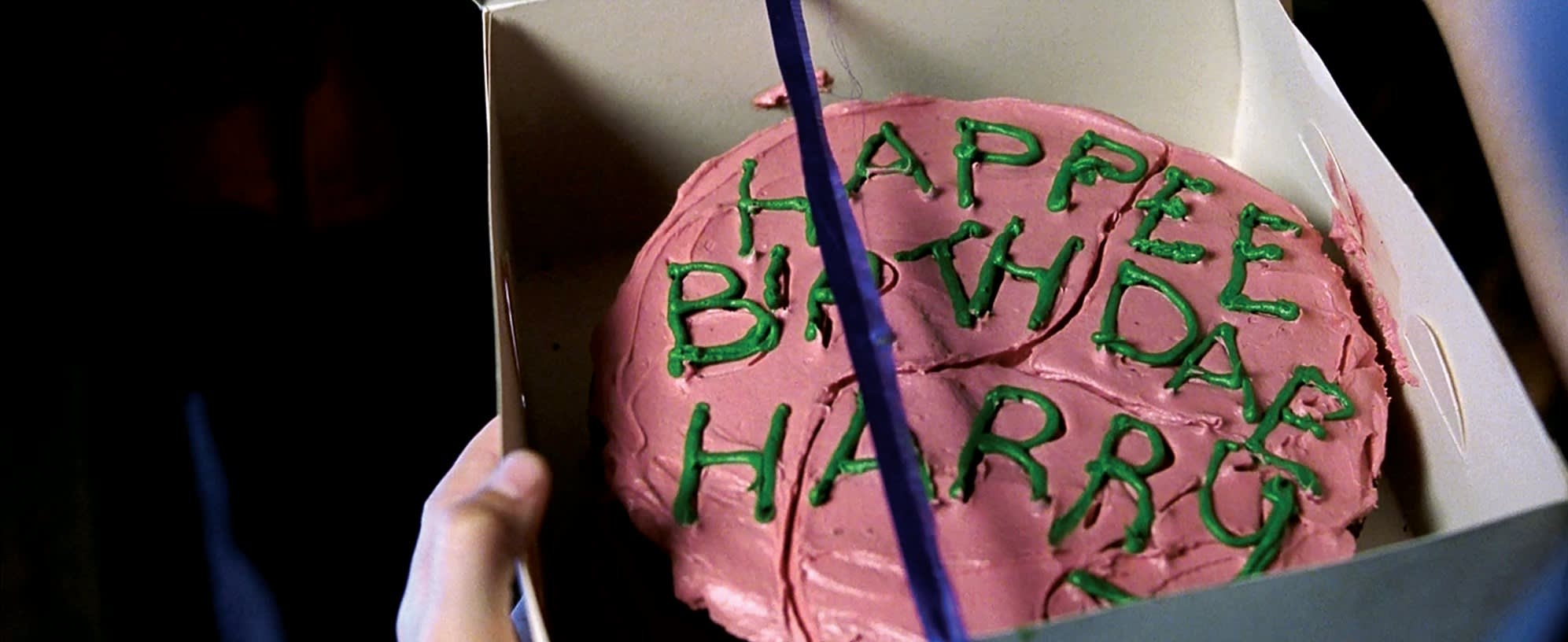 A close up image of Harry's pink birthday cake with green icing. 
