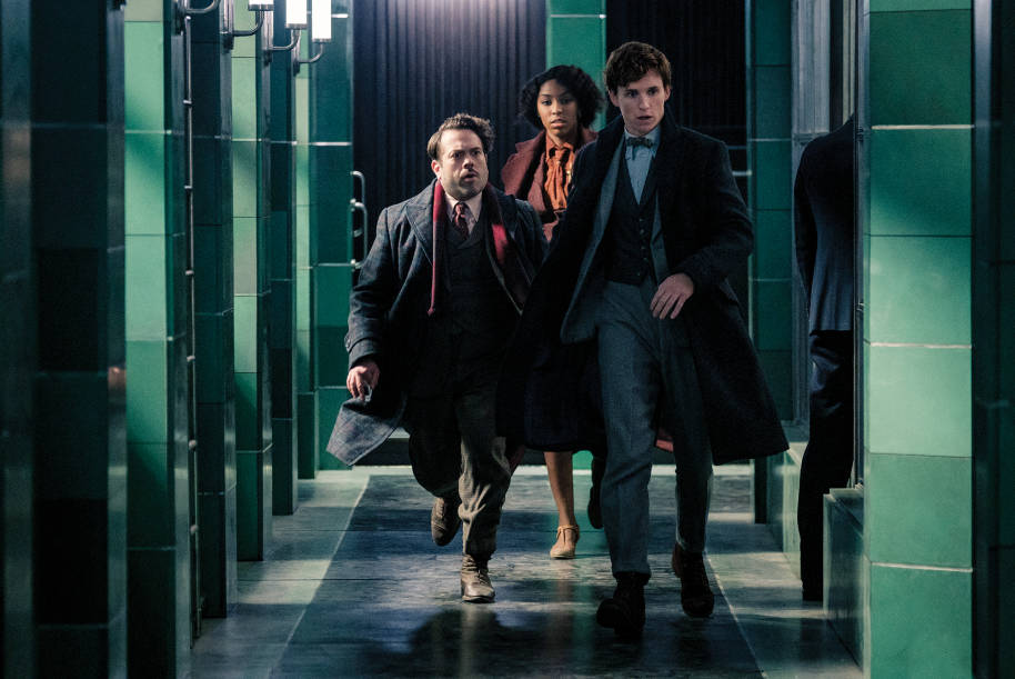 Jacob, Newt and Lally are purposefully walking through a corridor at the German Ministry of Magic.