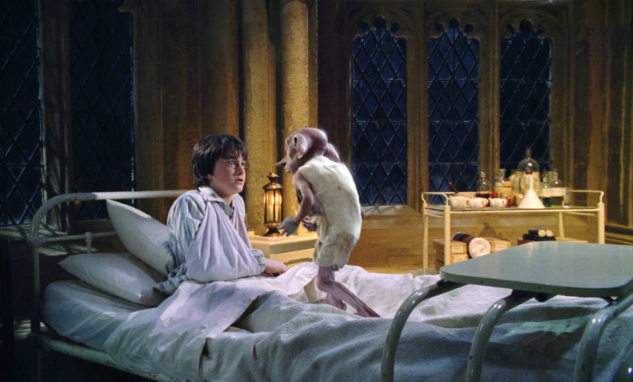 Dobby stands on Harry's hospital bed.
